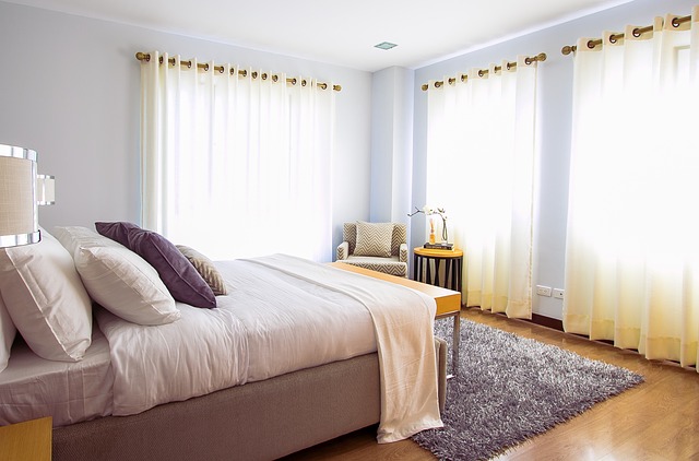 Bright sun-lit bedroom with open windows. Darkening the room with heavy curtains can help seniors sleep better.