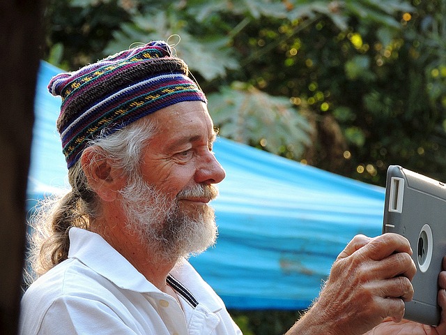 older man holding ipad