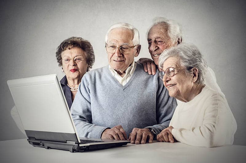 a group of seniors looking at a computer screen together