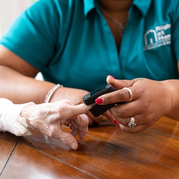 A female nurse attaches a line to an IV bottle.