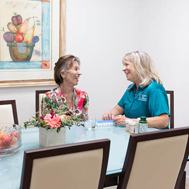 medication management A female Right at Home caregiver is helping her senior female client with her medication