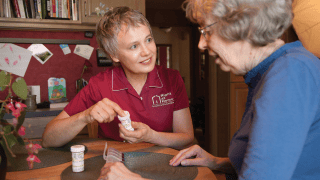 A caregiver and her patient discuss medication.